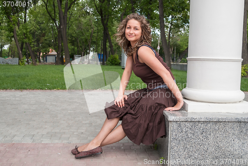 Image of portrait of young beautiful woman in city park