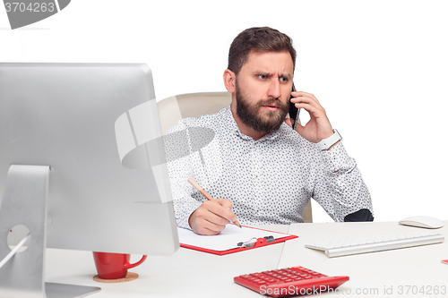 Image of Portrait of businessman talking on mobile phone in office