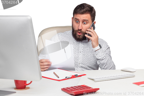 Image of Portrait of businessman talking on mobile phone in office