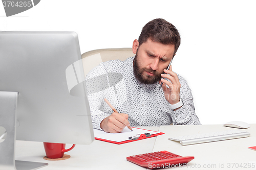 Image of Portrait of businessman talking on mobile phone in office