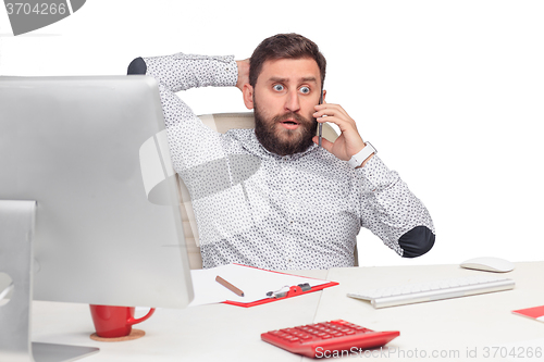 Image of Portrait of businessman talking on mobile phone in office