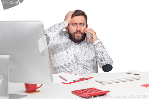 Image of Portrait of businessman talking on mobile phone in office