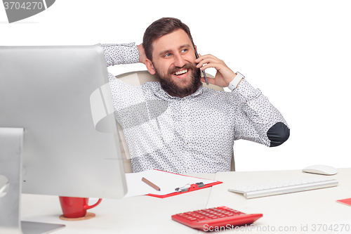 Image of Portrait of businessman talking on mobile phone in office