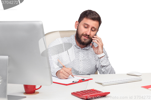 Image of Portrait of businessman talking on mobile phone in office