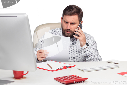 Image of Portrait of businessman talking on mobile phone in office