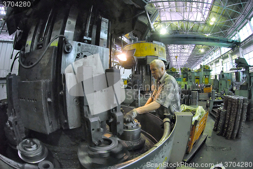 Image of Elderly worker watches on milling machine work