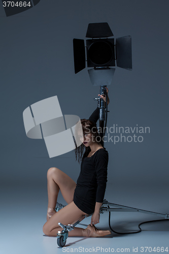 Image of The beautiful ballerina posing on dack blue background  