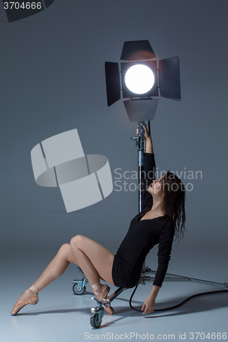 Image of The beautiful ballerina posing on dack blue background  