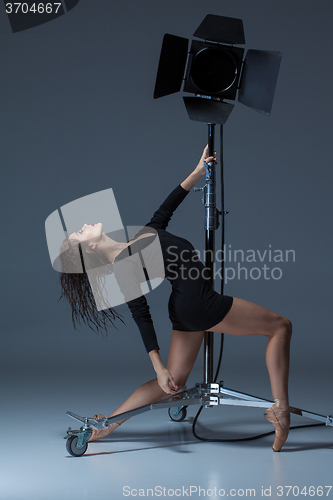 Image of The beautiful ballerina posing on dack blue background  