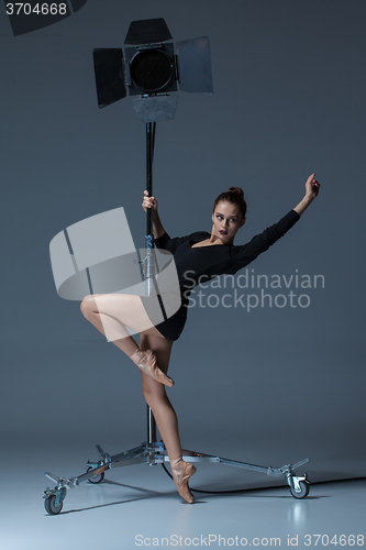 Image of The beautiful ballerina posing on dack blue background  