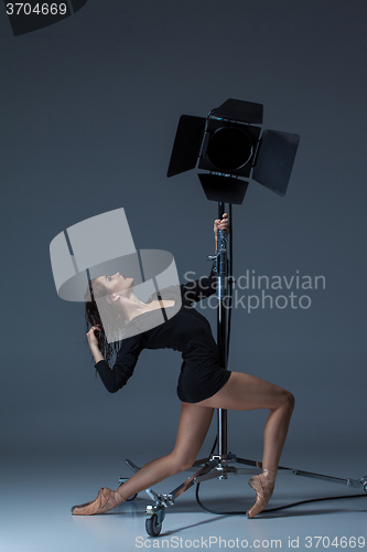 Image of The beautiful ballerina posing on dack blue background  