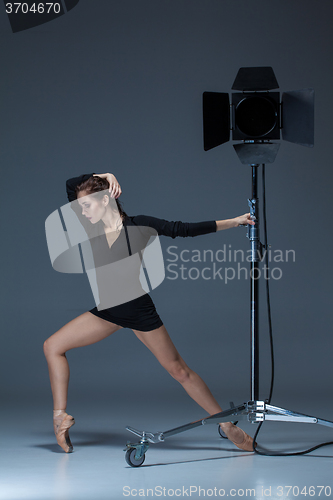 Image of The beautiful ballerina posing on dack blue background  