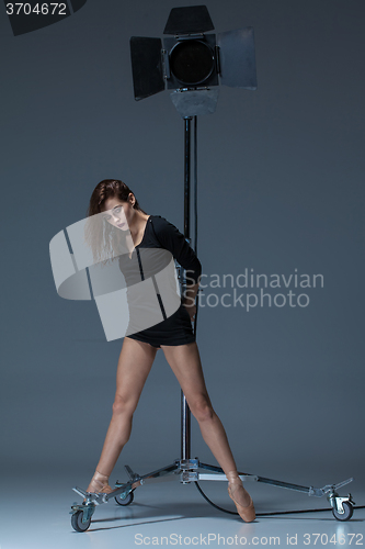 Image of The beautiful ballerina posing on dack blue background  