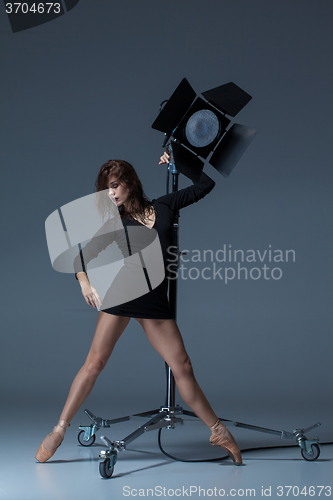 Image of The beautiful ballerina posing on dack blue background  