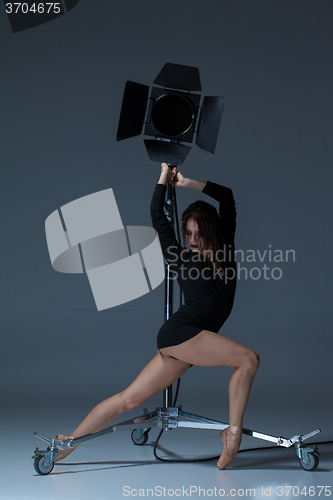 Image of The beautiful ballerina posing on dack blue background  