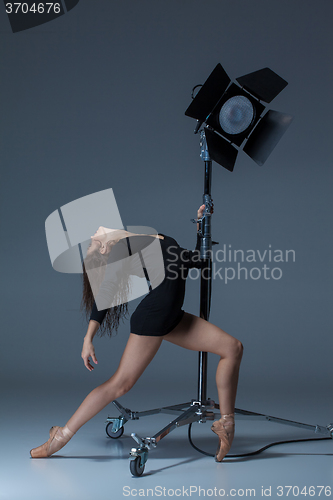 Image of The beautiful ballerina posing on dack blue background  