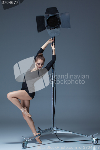 Image of The beautiful ballerina posing on dack blue background  