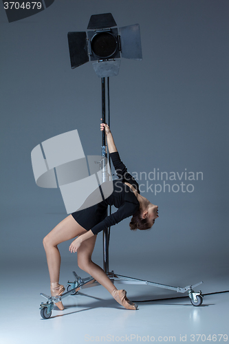 Image of The beautiful ballerina posing on dack blue background  