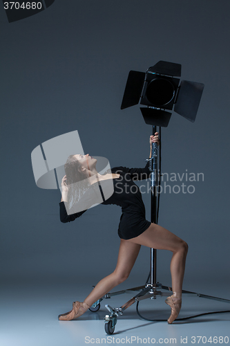 Image of The beautiful ballerina posing on dack blue background  