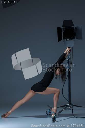 Image of The beautiful ballerina posing on dack blue background  