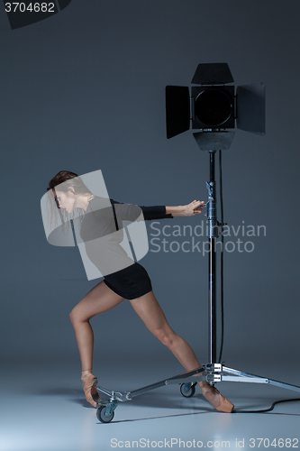 Image of The beautiful ballerina posing on dack blue background  