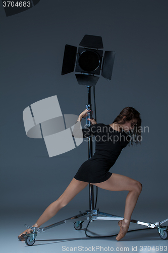 Image of The beautiful ballerina posing on dack blue background  