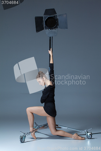 Image of The beautiful ballerina posing on dack blue background  