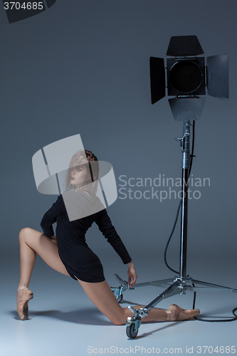 Image of The beautiful ballerina posing on dack blue background  