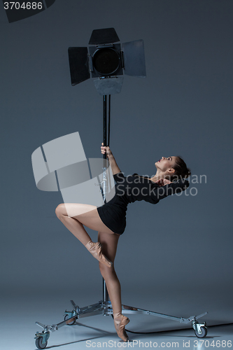 Image of The beautiful ballerina posing on dack blue background  