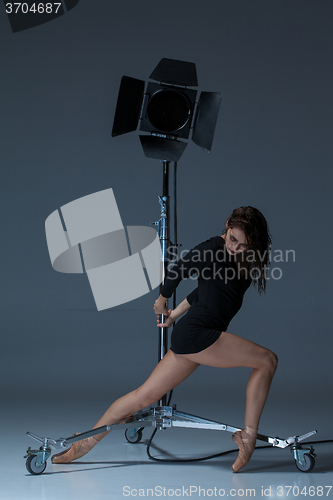 Image of The beautiful ballerina posing on dack blue background  