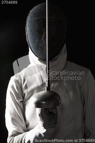 Image of The portrait of woman wearing white fencing costume  on black 