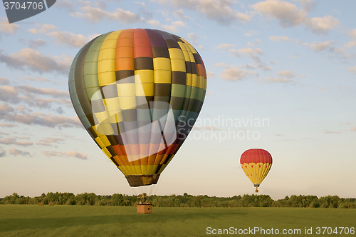 Image of Two hot-air balloons in a field