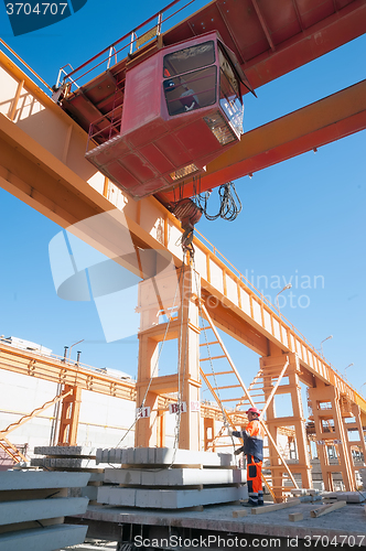 Image of Slinger with crane operator work on loading