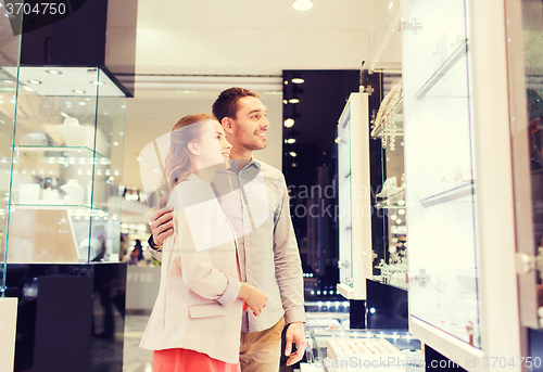 Image of couple looking to shopping window at jewelry store