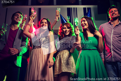 Image of smiling friends with glasses of champagne in club