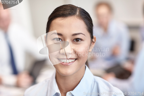 Image of group of smiling businesspeople meeting in office