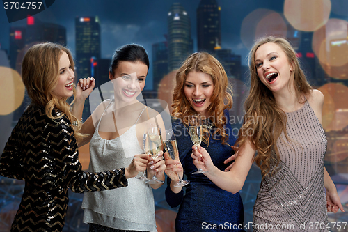 Image of happy women clinking champagne glasses over city