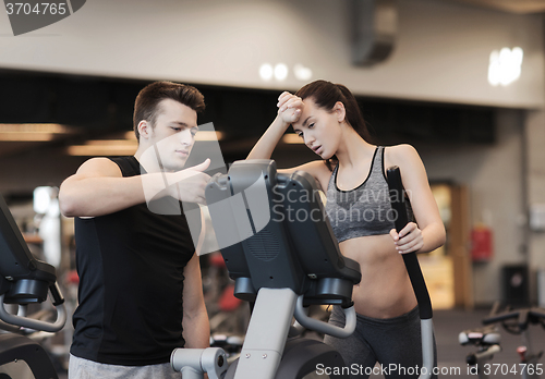 Image of woman with trainer exercising on stepper in gym