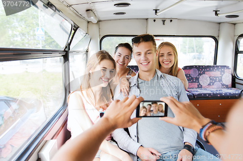 Image of smiling friends with smartphone taking picture