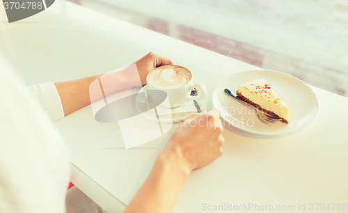 Image of close up of woman hands with cake and coffee