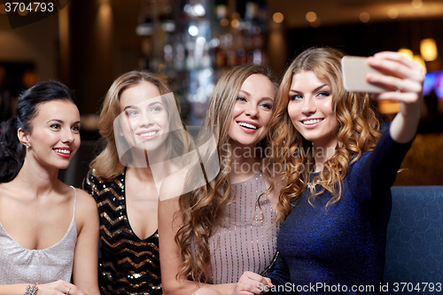 Image of women with smartphone taking selfie at night club