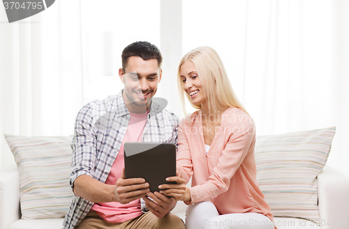 Image of smiling happy couple with tablet pc at home