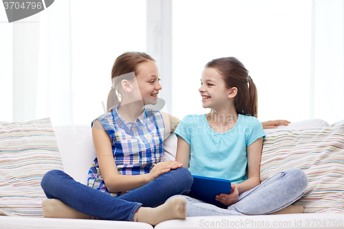 Image of happy girls with tablet pc talking at home