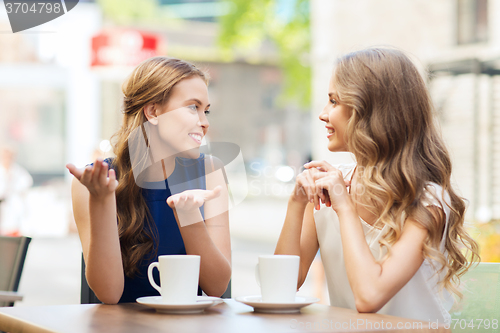 Image of young women drinking coffee and talking at cafe