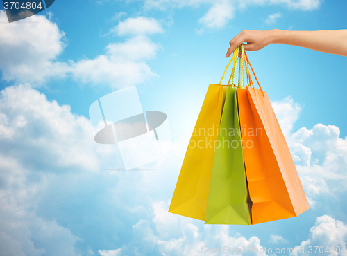 Image of close up of hand holding shopping bags