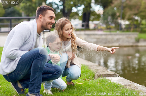 Image of happy family walking in summer park