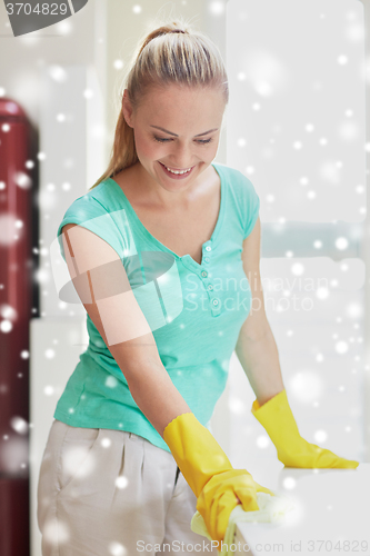 Image of happy woman cleaning table at home kitchen