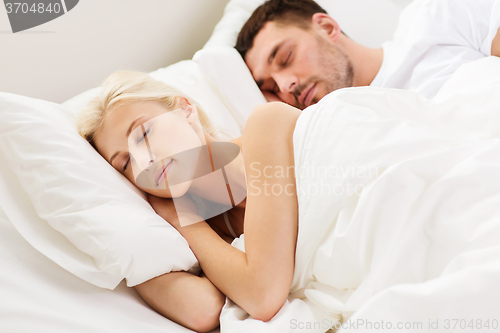 Image of happy couple sleeping in bed at home