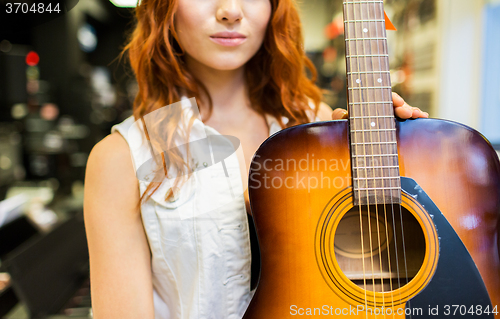 Image of close up of woman with guitar at music store