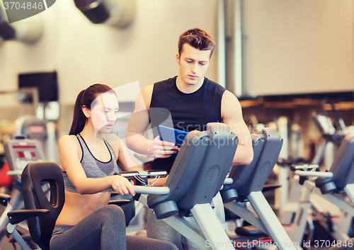 Image of woman with trainer on exercise bike in gym